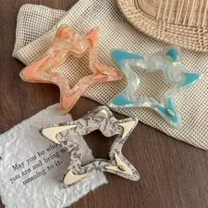 Detail shot of hollow star hair claw, trendy acetate shark clip for elegant daily hair styling.