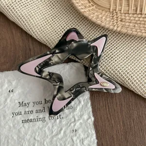 Detail shot of stylish hollow star hair claw clip with acetate tortoiseshell and pink accents.