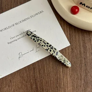 Elegant acetate hair clip with chic pattern and gold letters for daily fashion styling.