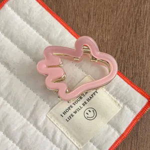 Gros plan détaillé d'une jolie pince à cheveux rose avec ressort pour un style quotidien.