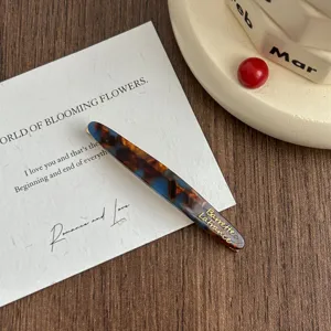 Elegant tortoiseshell acetate hair clip with gold lettering, stylish side bobby pin for women.