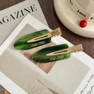 Green acetate hair clip detail, stylish metal duckbill design, perfect for bangs accessory.