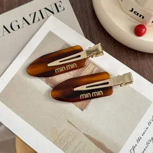 Chic tortoiseshell acetate duckbill hair clip, gold metal accent, trendy sweet hair accessory.