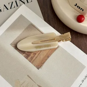Close-up detail of the stylish acetate hair clip, elegant gold metal clip design.