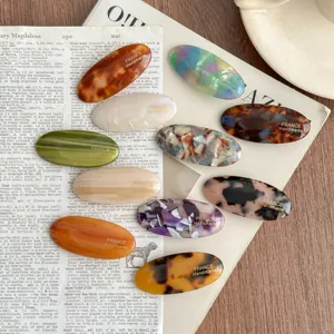 Detailed shot of assorted oval acetate hair clips featuring elegant tortoise shell and colors.