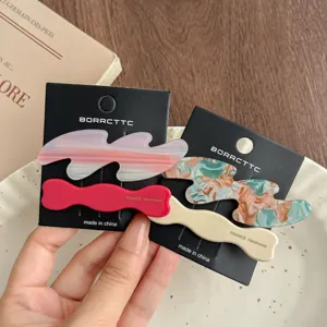 Detailed view of chic acetate hair clips with wavy design and elegant handmade finish cards.