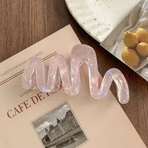 Detail shot of the elegant wave acetate hair claw clip with mermaid pink iridescent finish.