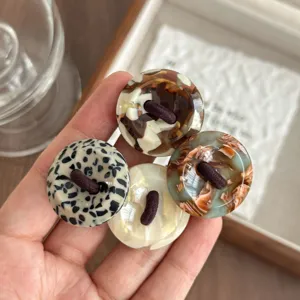 Detailed close-up shot of retro acetate button hair ties featuring stylish tortoiseshell and leopard designs.