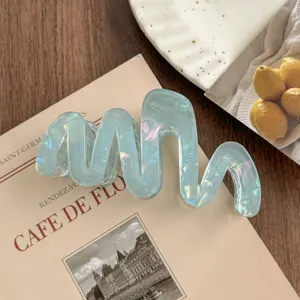 Detail view of the elegant wavy hair claw clip, featuring a unique iridescent finish.