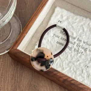 Retro acetate tortoiseshell button hair tie detail view, showcasing elegant daily style.