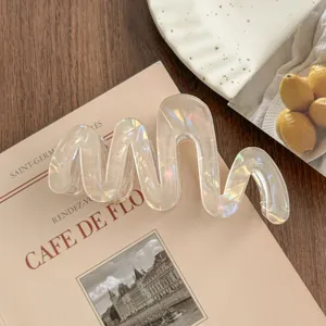 Detailed shot of the iridescent wavy hair claw clip, showcasing its glossy finish and unique curve.
