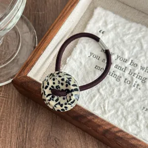 Retro tortoiseshell acetate button hair tie detail shot, showing unique pattern and texture.