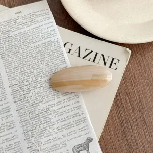 Detailed view of an elegant acetate oval hair clip with vintage styling and smooth texture.