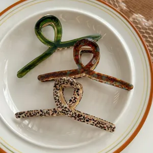 Close-up detail of stylish acetate hair claws featuring unique loop design and vibrant patterns.