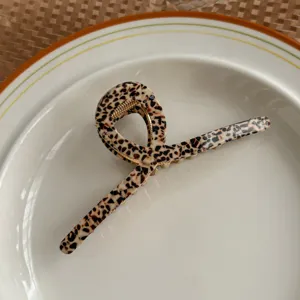 Detailed close-up of a stylish tortoiseshell acetate hair claw clip with unique design.