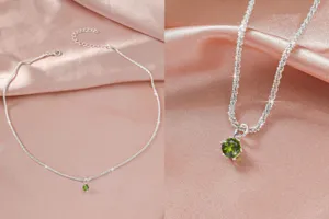 Close-up details van de sprankelende zilveren ketting met groene edelsteen hanger op zijde.