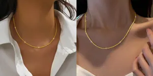 Detailopname van de delicate sprankelende gouden sleutelbeinketting met fijne schakels.