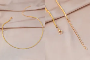 Gouden ketting halsketting detailweergave, fijne metaaltextuur, karabijnhaak en verlenging.