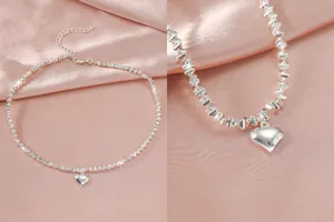 Close-up detailopname van zilveren gefacetteerde kralenketting met glanzende hartvormige hanger.