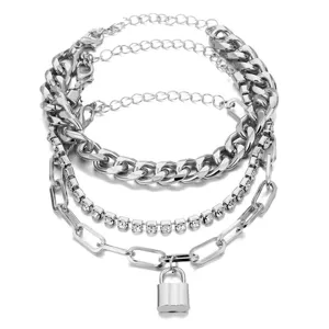 Primo piano del bracciale a catena in metallo argentato multistrato con strass e lucchetto.
