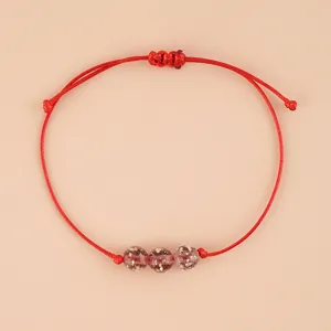 Handmade red cord bracelet with three sparkling glass beads and adjustable sliding knot.