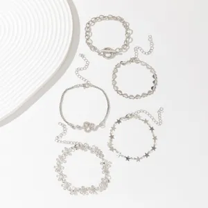 Close-up detail of a 5-piece silver bracelet set featuring charming stars, hearts, and floral links.
