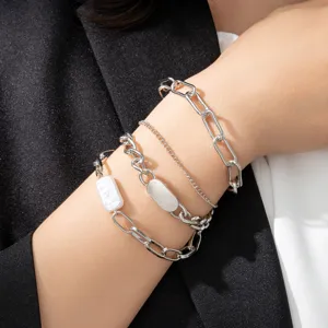 Detail shot of a four-piece multi-chain bracelet set featuring silver-tone links and pearls.