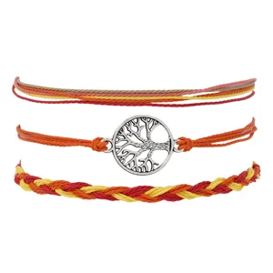 Détail de bracelet tressé à la main avec pendentif arbre de vie argenté et couleurs d'automne.