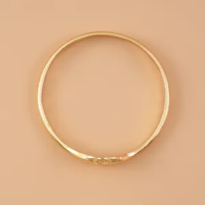 Vue détaillée du bracelet mains entrelacées dorées, bijoux jonc en métal élégant.
