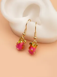 Dettaglio ravvicinato di orecchini pendenti a forma di pitaya rosa e giallo su espositore.
