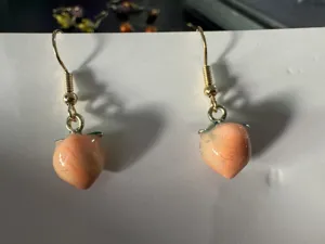 Primo piano dettagliato degli orecchini pendenti con pesca, gioielli stile coreano.