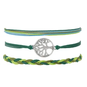 Vue rapprochée du détail du bracelet tissé à la main avec un pendentif arbre de vie argenté.