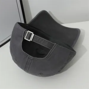 Detail view of the dark grey cotton baseball cap showing adjustable metal buckle strap.