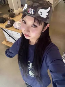 Vue détaillée de la casquette de baseball camouflage streetwear coréenne avec ailes et sweat.