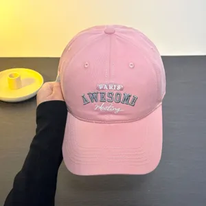 Pink baseball cap detail view, featuring stylish embroidered text and curved brim for sun protection.