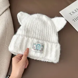 Bonnet chat tricoté blanc chaud hiver pour femme avec un joli label brodé sur le devant.