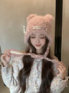 Detail view of the pink fuzzy knit beanie with cute bear ears and stylish braided tassel strings.