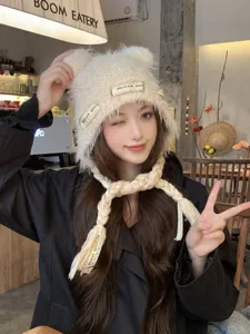 Cozy knit bear ear hat with braided earflaps, soft fuzzy material for winter warmth and sweet style.