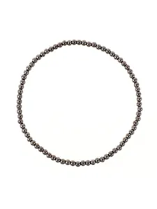 Vista dettagliata di perine metalliche rotonde su bracciale elastico, elegante e versatile ogni giorno.