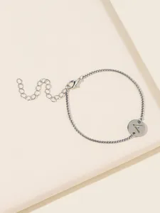 Detailaufnahme des silbernen Ankerkettchen-Armbands mit rundem Anhänger und dem Buchstaben A.