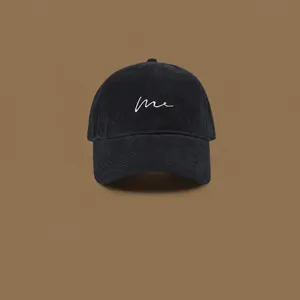 Detail view of a stylish black baseball hat with white embroidery 'me', premium look.