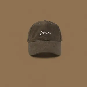 Close-up detail of the stylish brown baseball cap with clean embroidery and textured fabric.