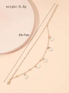 Double layer gold anklet featuring sweet white enamel flower pendants and delicate chain links.