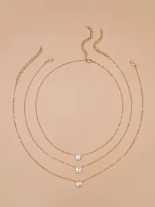 Layered gold-tone necklace set featuring sparkling heart-shaped cubic zirconia crystal pendants.
