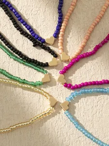 Cavigliere con perline di vetro colorate boho con ciondoli a cuore dorati, gioielli da piede eleganti.