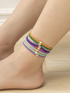 Set di cavigliere con perline colorate e ciondoli a cuore dorati, gioielli boho estivi.
