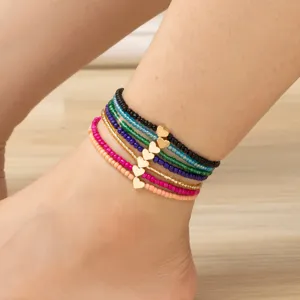 Cavigliera bohémien multistrato con perline di vetro colorate e ciondolo cuore dorato donna.