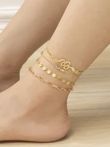 Detailed view of a 4-piece layered gold anklet set featuring a rhinestone snake charm and delicate hearts.