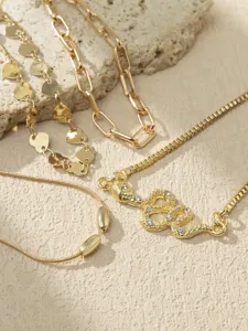Gold anklet set featuring heart chain, chunky link, and rhinestone snake pendant design.