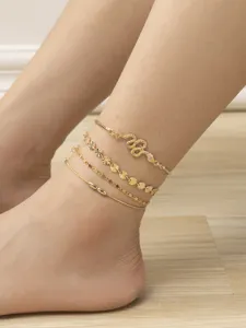 Gold layered anklet set featuring a rhinestone snake pendant and delicate chains.
